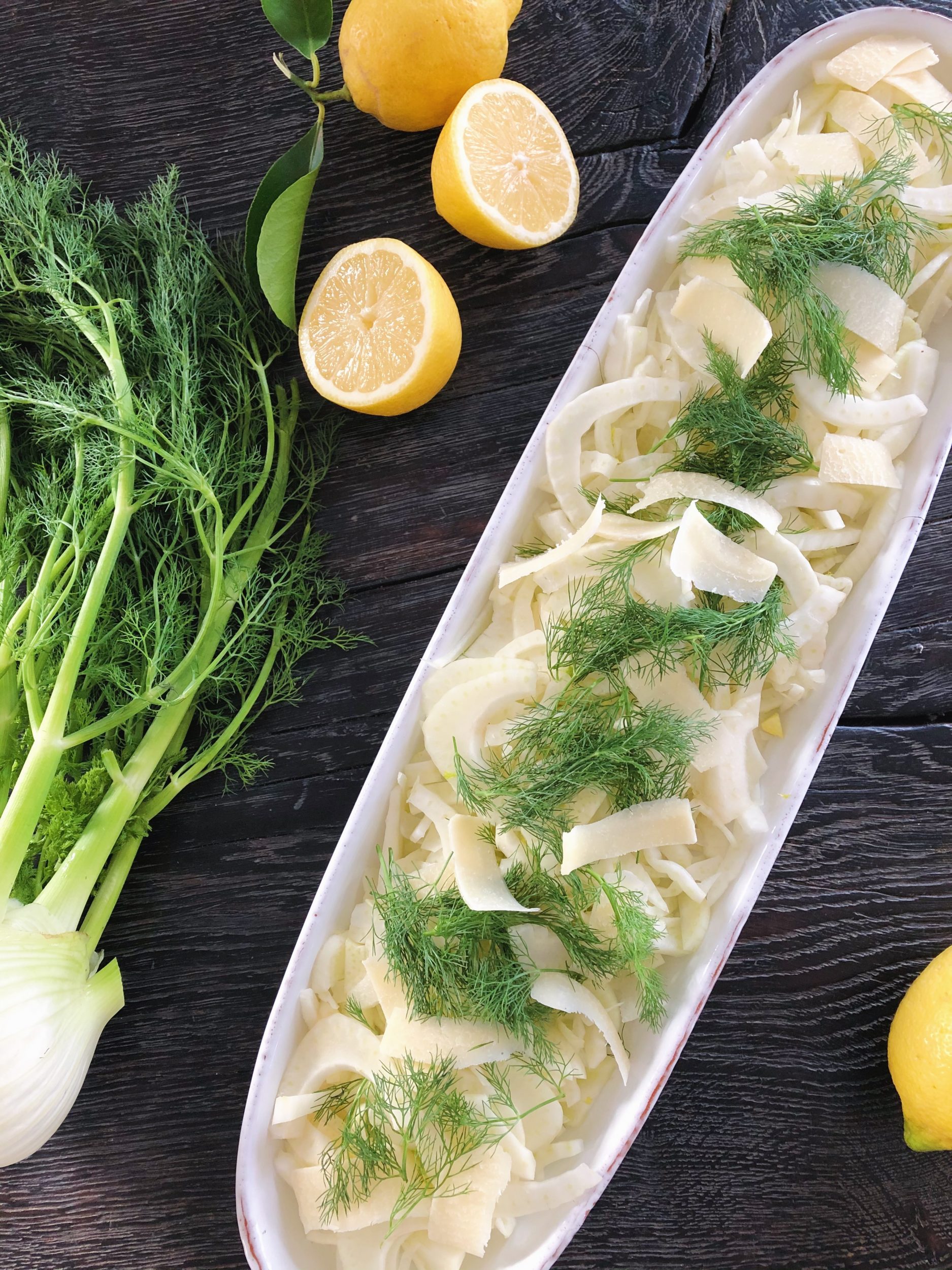 fennikelsalat ses serveret i hvidt aflangt fad.