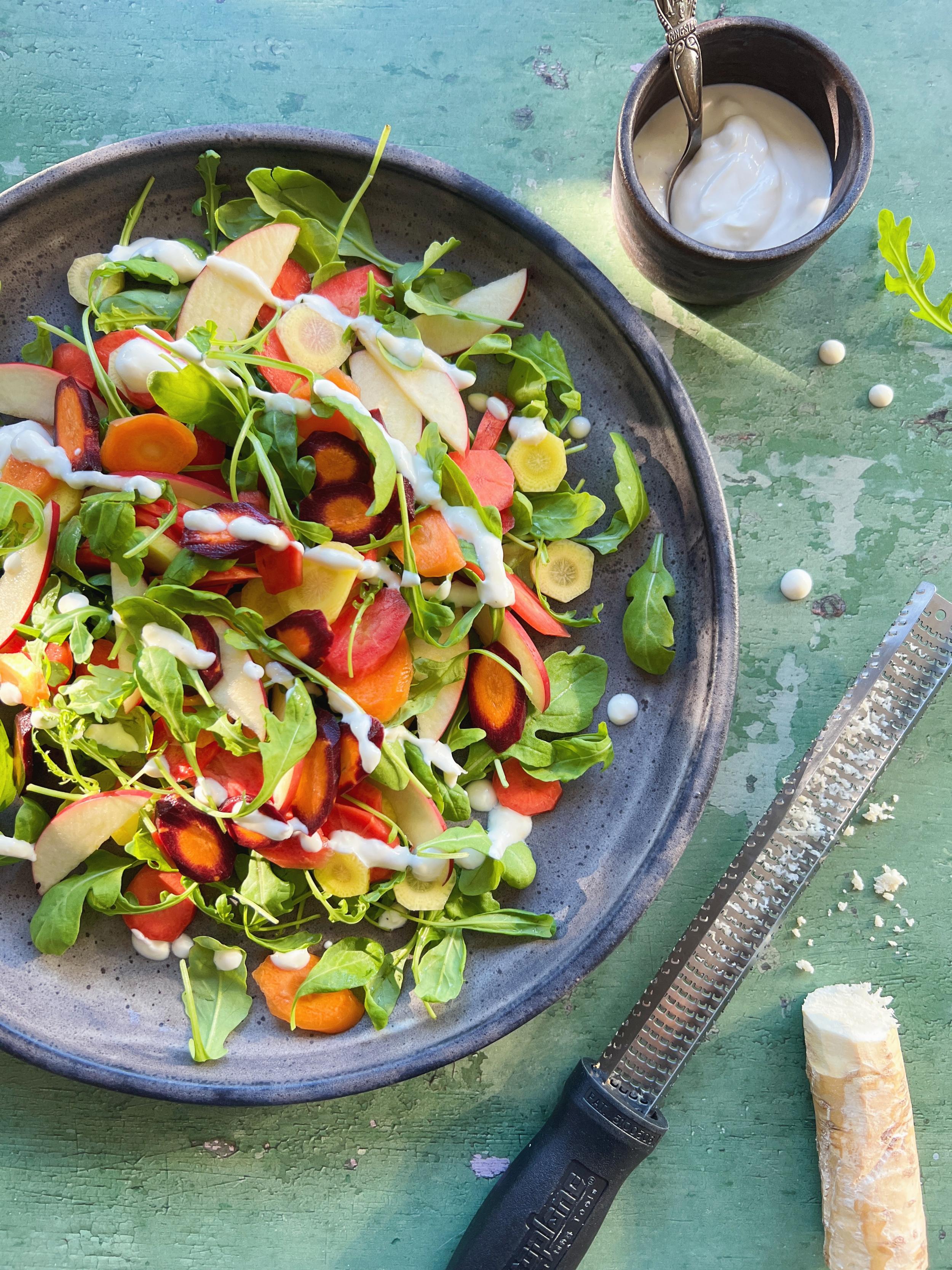 Salat med gulerødder, æbler og rucola toppet med cremet peberrodsdressing