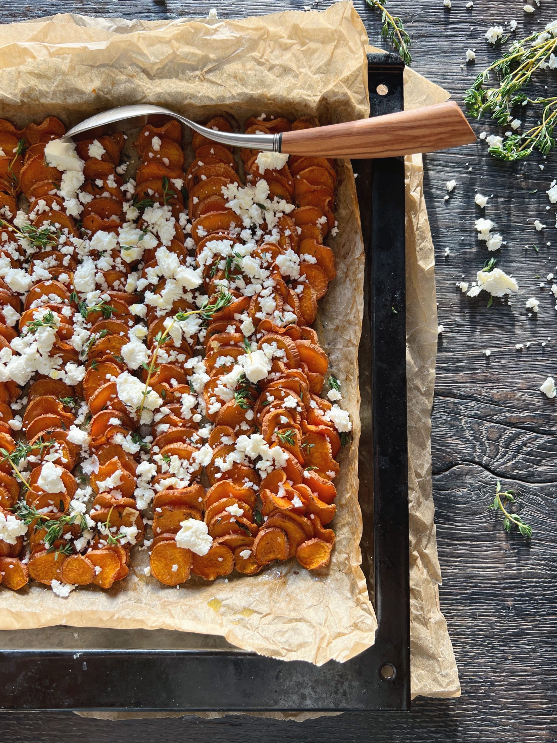 Bagte søde kartofler skåret i skiver toppet med krydderier og smuldret feta